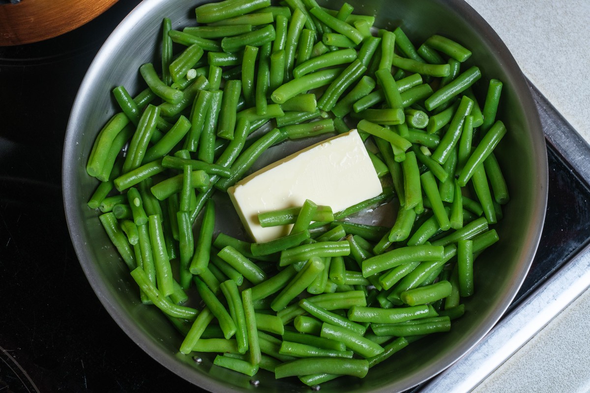 Blanchierte grüne Bohnen mit Butter in der Pfanne