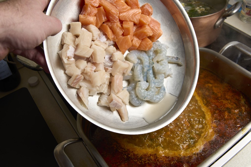 Fischsuppe mit rohem Fisch ergänzen