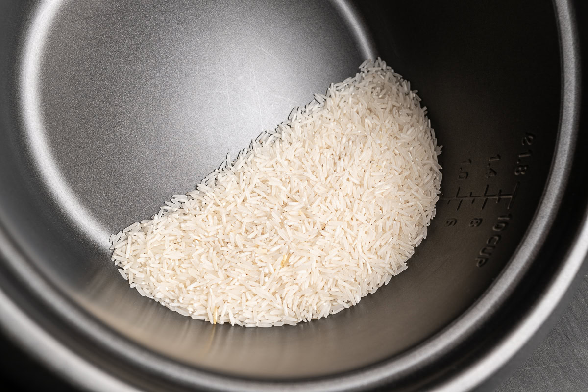 Reis im Reiskocher Topf vor dem Waschen