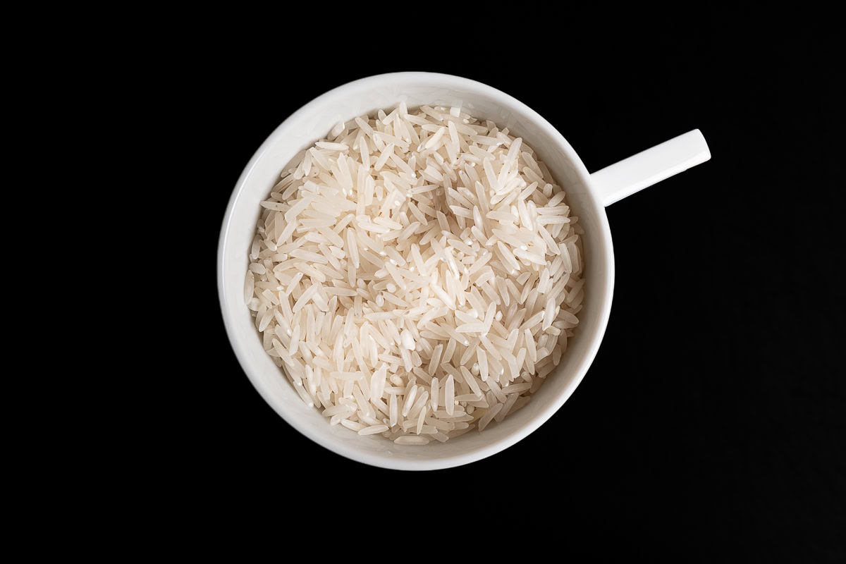 Reis zum Kochen in der Tasse abwiegen.