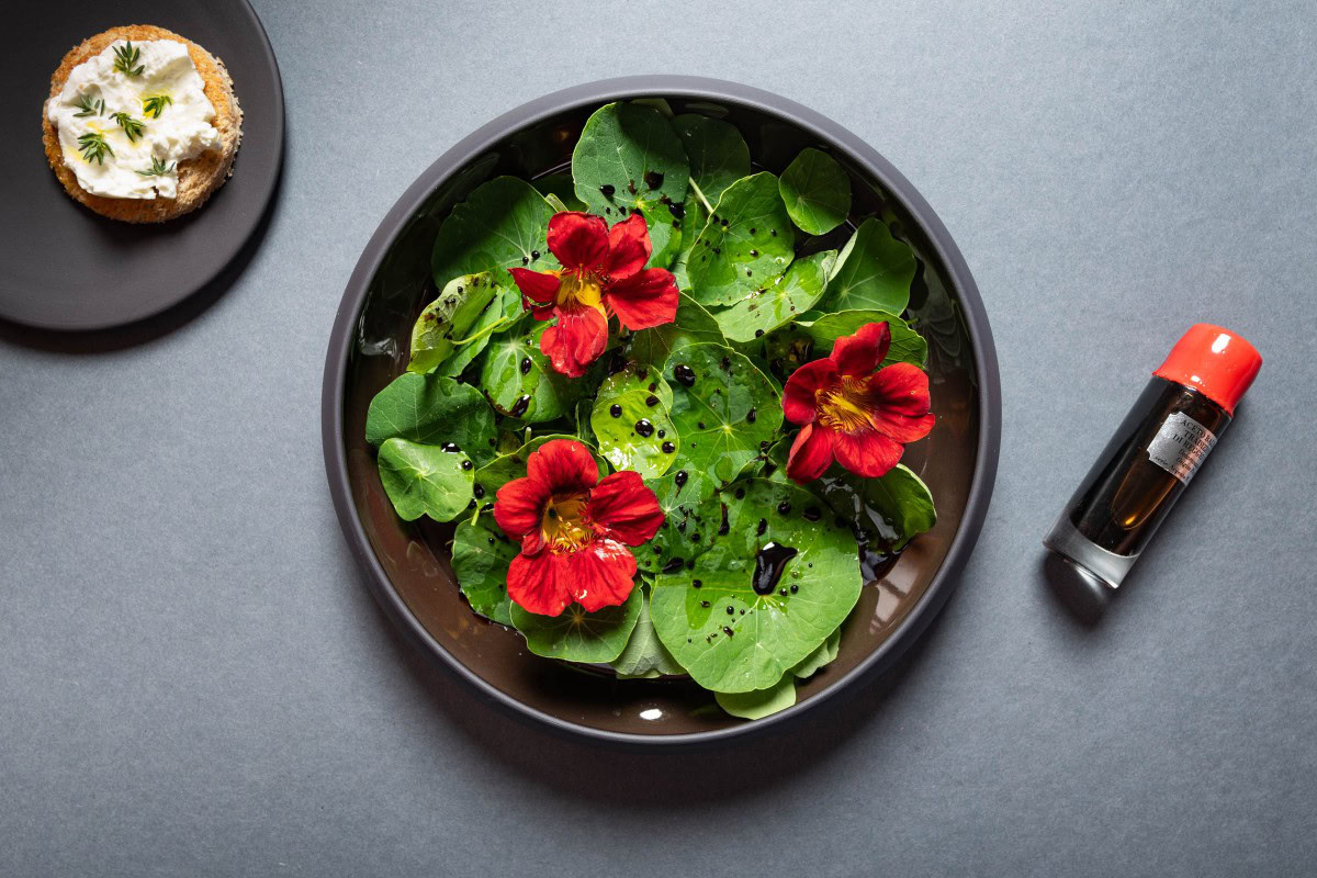 Kapuzinerkresse-Salat mit Blüten servieren