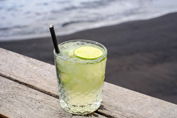 Caipiroska Cocktail schwarzer Strand Hintergrund