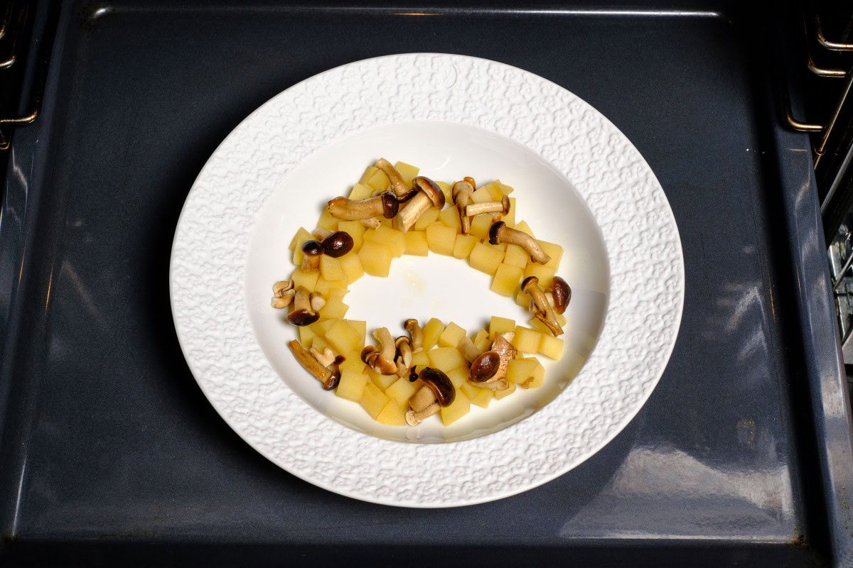 Kartoffeln und Pilze auf Teller angerichtet im Backofen warm stellen.