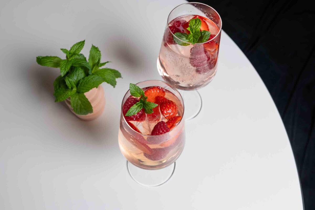 Zwei Gläser Lillet Wild Berry mit Eis, Beeren und Minze – von oben fotografiert