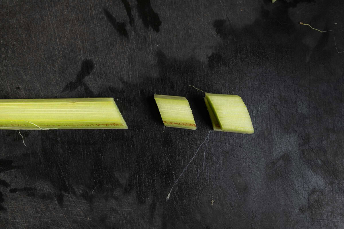 Rhabarberstange wird in schräge Stücke geschnitten.